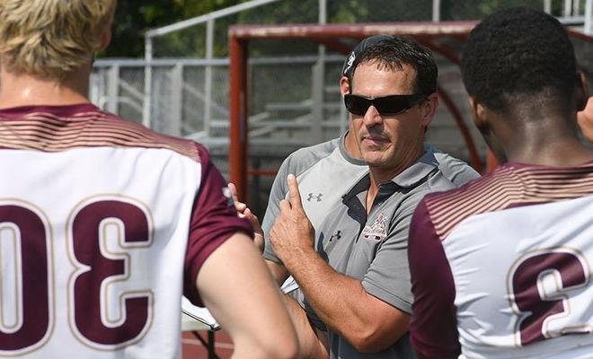 Coach with players on field, sports management